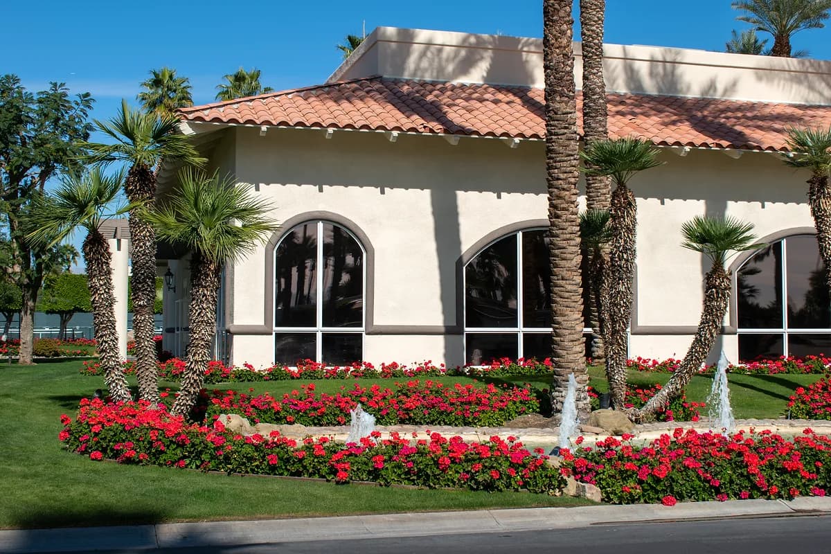 Clubhouse with red geraniums and mini fountains