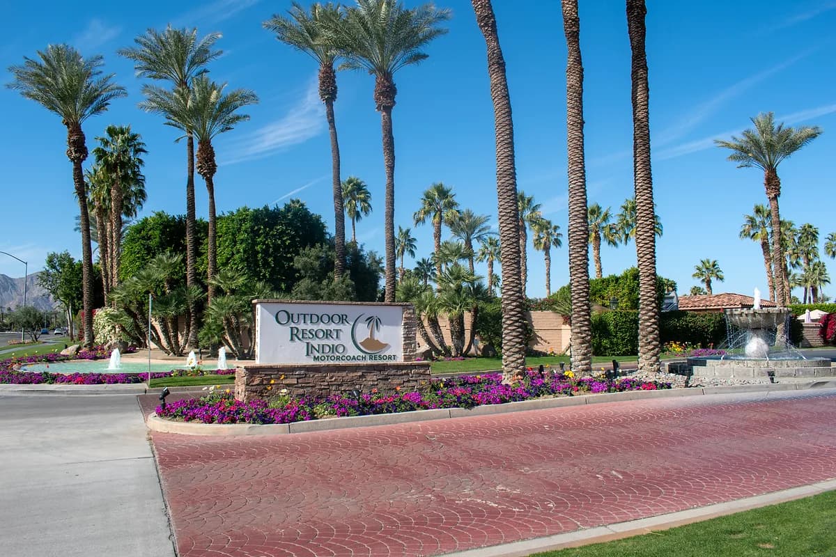 Resort entrance sign with fountain and colorful flowers